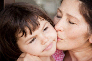 Grandmother kissing granddaughter 
