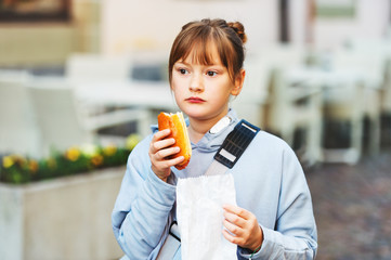 Fototapeta premium Adorable kid girl eating salami sandwich during school break