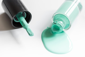 Bottles with spilled nail polish over white background mockup