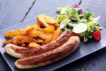 grilled sausages and potatoes and salad