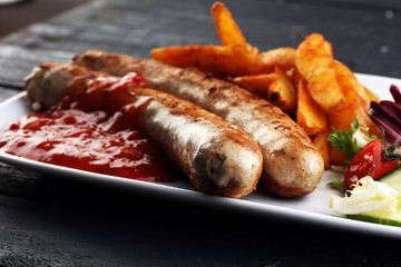 grilled sausages and potatoes and salad