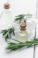 Fototapeta na wymiar close up body care rosemary cosmetic products on white wooden desk background