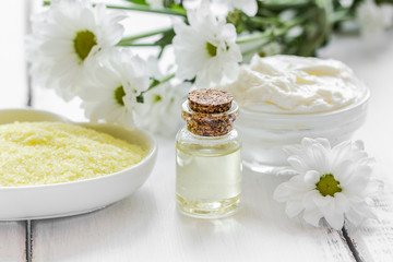 camomile essential oil in glass bottle in cosmetic set on table background