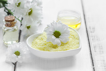 Obraz na płótnie Canvas close up body care camomile cosmetic products on white wooden desk background