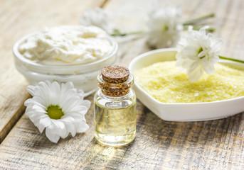 camomile essential oil in glass bottle in cosmetic set on table background