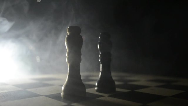 chess board game concept of business ideas and competition and strategy ideas concep. Chess figures on a dark background with smoke and fog. Selective focus