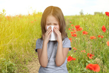 Seasonal allergy. Little girl with tissue outdoor