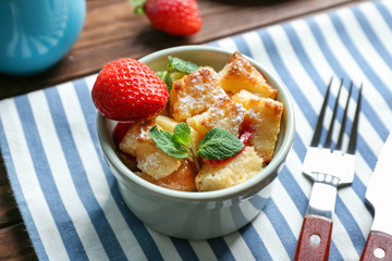 Delicious bread pudding with strawberry and mint on wooden table