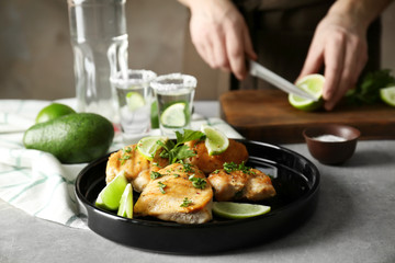 Plate of delicious tequila lime chicken and woman on background