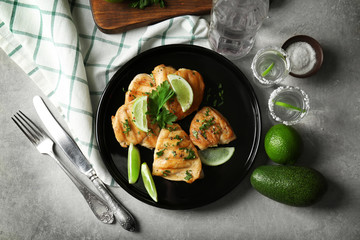 Plate of delicious tequila lime chicken with ingredients on light background