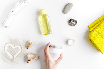 Cosmetic bottle with cream on white background top view