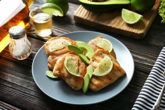 Plate of delicious tequila lime chicken on wooden background