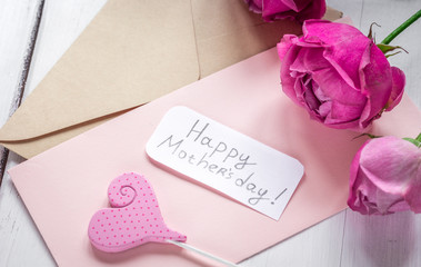 pink peony and greeting-card for Mother's day present on wooden background