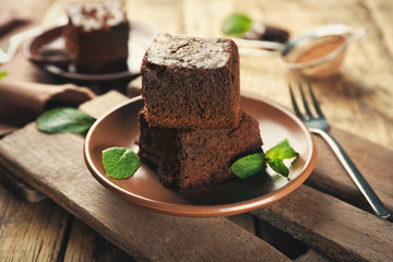 Plate with delicious cocoa brownies on wooden table