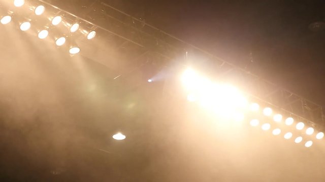 A pan across stage lights with heavy fog