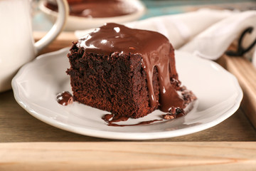 Wooden tray with delicious cocoa brownie on table