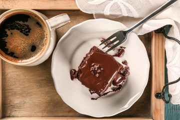 Wooden tray with delicious cocoa brownie on table