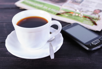 Cup of coffee and newspaper with glasses