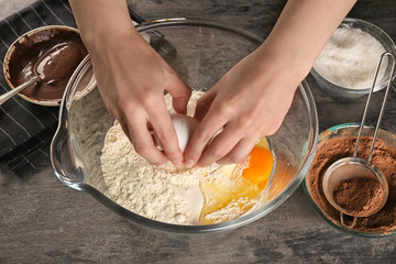 Woman preparing dough for cocoa brownies on table