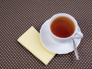 White cup of tea standing on a napkin