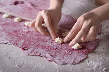 Woman making ravioli on table