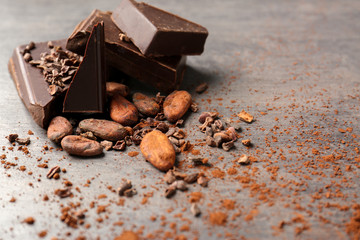 Composition with cocoa beans and pieces of chocolate on table