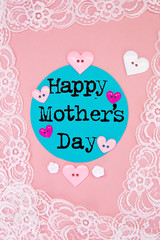 Sewing -  Happy Mother's Day with lace and buttons on pink background
