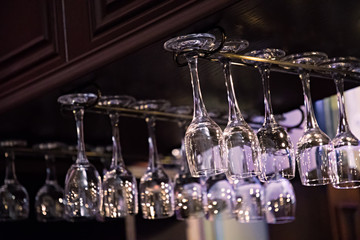 Empty glasses for wine above a bar rack