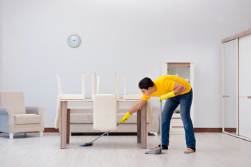 Fototapeta premium Man cleaning the house helping his wife