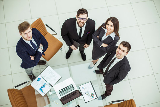professional business team looking up standing near desktop - Powered by Adobe