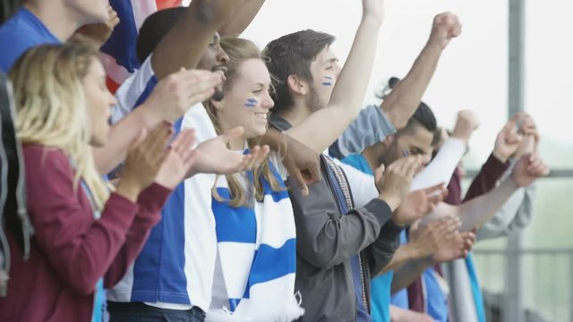  Excited sports fans at live event clapping & cheering for their team
