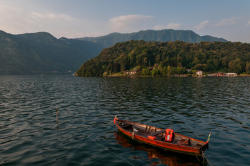 Lake Como and fisherman boat - early morning in summer season.