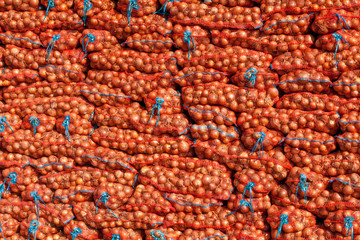 stack of onion bag. onion  stacked for sale. Fresh onion in a market