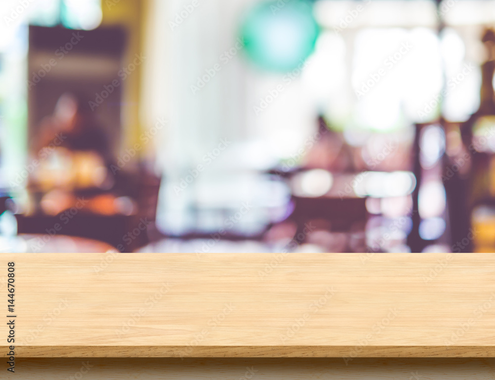 Poster Empty wooden brown table top at blur restaurant background with bokeh light, Mock up template for display or montage of product,Food Business presentation