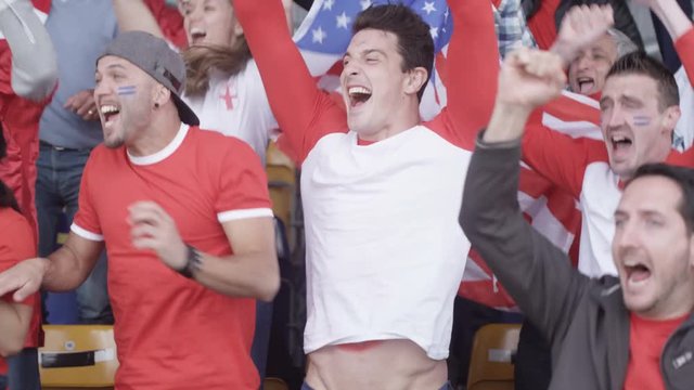  USA sports fans watching game pull up t.shirts to show USA written on torsos