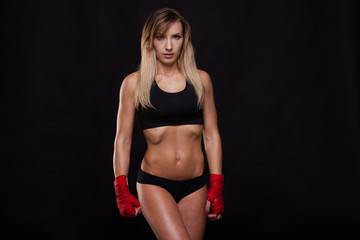athletic girl posing in red bandages, isolated on the black background