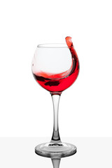 Splash of red wine in the cup filling on a white background