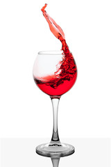 Splash of red wine in the cup filling on a white background