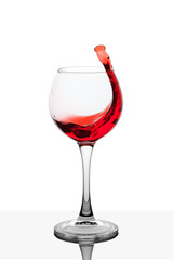 Splash of red wine in the cup filling on a white background