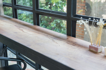 the empty wooden counter near grass window