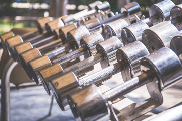 Rows of metal dumbbells on rack in the gym,Weight Training Equipment.