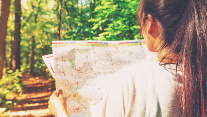 Woman in reading a map in the forest