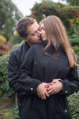 Fototapeta premium Young romantic couple hugging and kissing outside