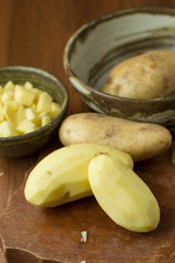 Potatoes and potato sliced on wooden table. Selective focus