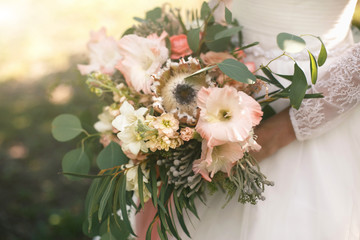 Closeup photo of a bridal bouquet of exotic flowers and greens