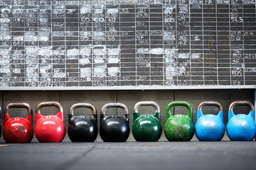Row of colorful pairs of kettlebell weights