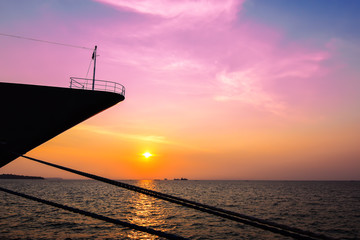 Silhouette of moored cruise ship at colorful sunset.