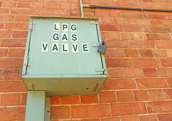 LPG gas valve container on a red brick wall