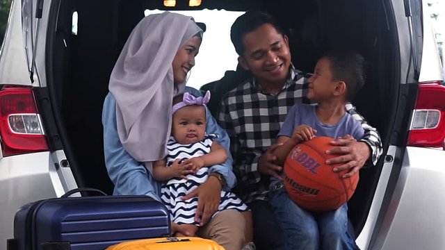 JAKARTA, April 12, 2017: Video footage of muslim family ready for road trip and sitting in the car while talking together