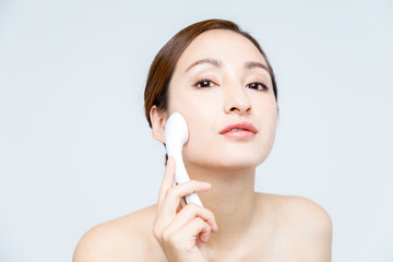 woman using handy iontophoresis instrument. skincare concept.